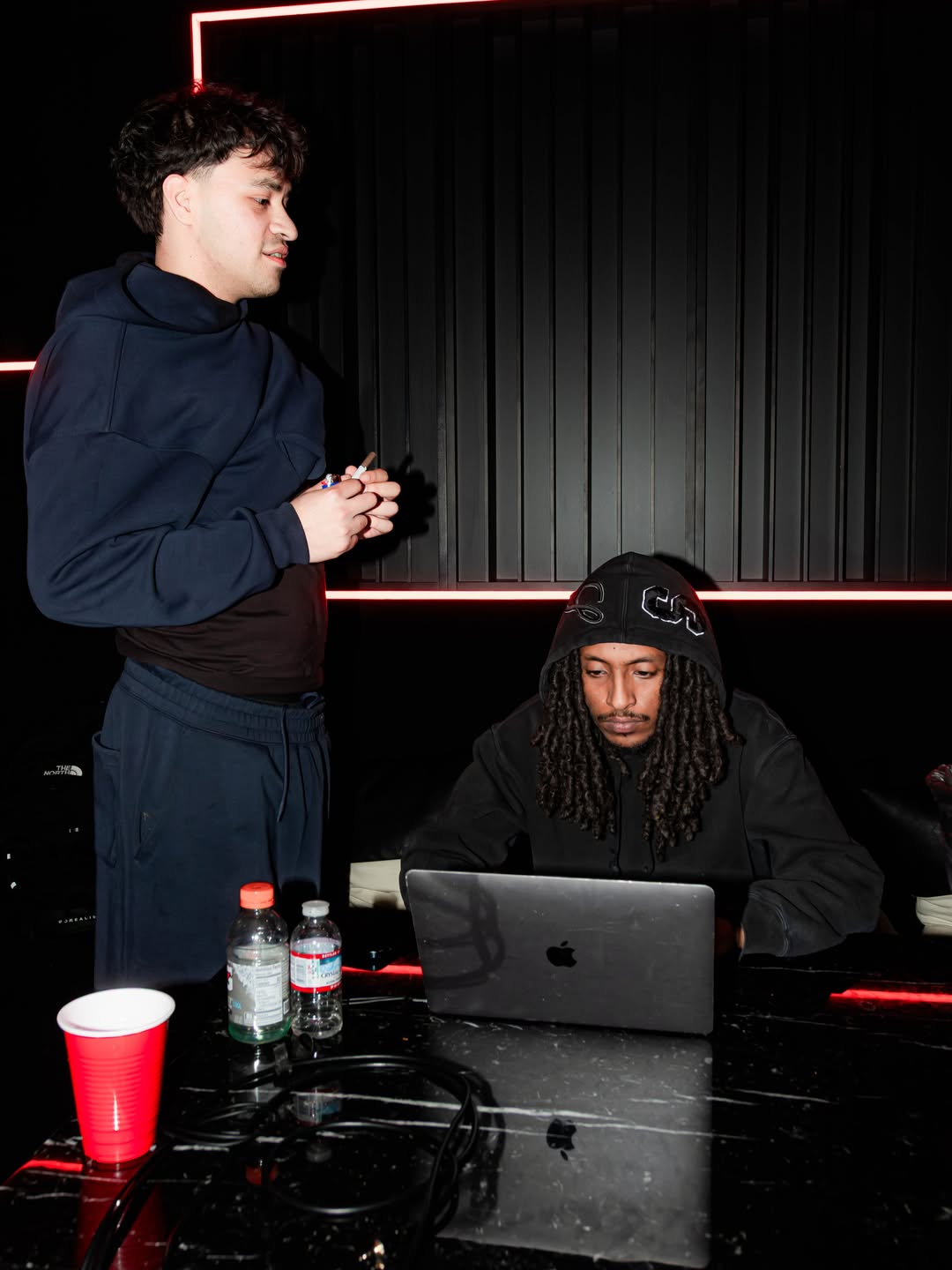 Two artists working at a laptop in a studio